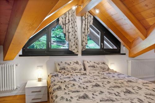 a bedroom with a bed and two windows at Sogno Alpino in Caspoggio