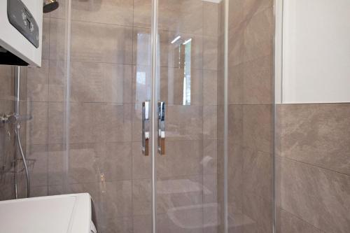 a shower with a glass door in a bathroom at Sogno Alpino in Caspoggio