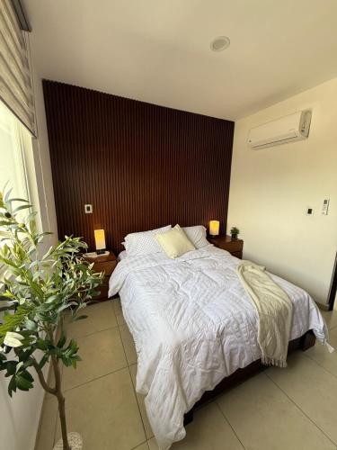 a bedroom with a large bed with white sheets at Casaaurea in Jesús María