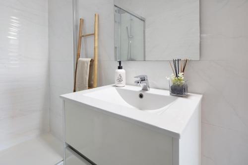 a white bathroom with a sink and a mirror at Ocean City View Loft in Ponta Delgada