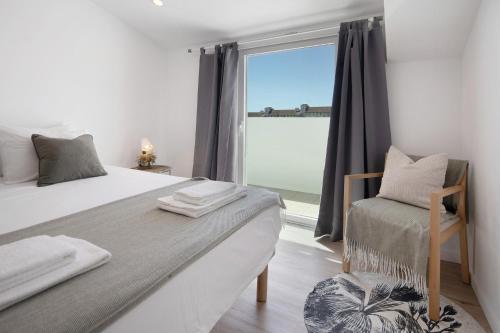 a bedroom with a large bed and a window at Ocean City View Loft in Ponta Delgada