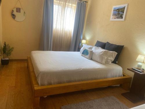 a bedroom with a bed with white sheets and pillows at Alojamento D Duarte in Gouveia