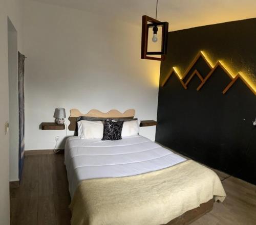 a bedroom with a large bed with a black wall at Alojamento D Duarte in Gouveia