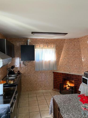 a kitchen with a fireplace in a room at Alojamento D Duarte in Gouveia