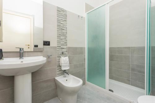 a bathroom with a sink and a toilet and a shower at La Papuzzella in Puntalazzo