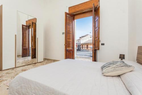a bedroom with a large bed and a large window at La Papuzzella in Puntalazzo