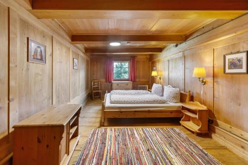 a bedroom with a bed and a wooden wall at Bachrainhof 2 in Menzenschwand