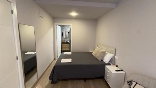 a small bedroom with a bed and a mirror at Suite Muralla 2.3-B in Lugo