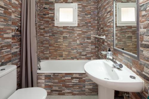 a bathroom with a sink and a tub and a toilet at Bright spacious 1 bed apartment in Nerja