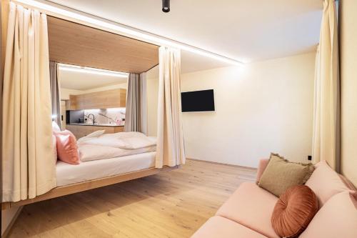 a hotel room with a bed and a couch at Avia Living Anna in Brunico