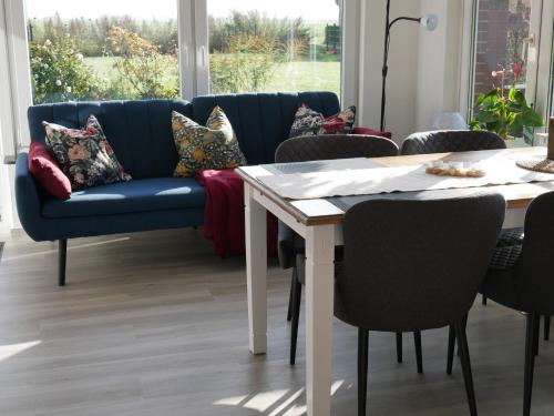 a living room with a blue couch and a table at Ferienwohnung Unter Reet in Risum-Lindholm