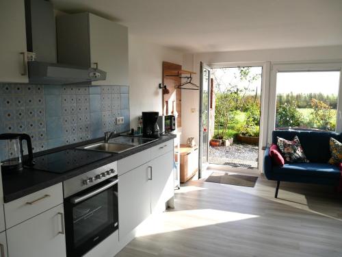 a kitchen with a sink and a stove top oven at Ferienwohnung Unter Reet in Risum-Lindholm