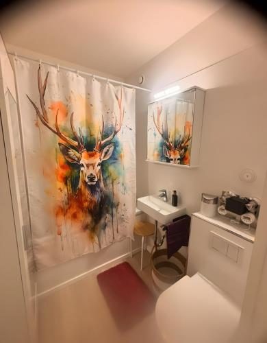 a bathroom with a painting of a deer on the wall at Über den Dächern von Aachen in Aachen