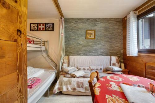 a bedroom with two bunk beds and a table at Les Airelles 32 in Villarodin-Bourget