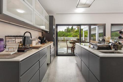 a kitchen with white cabinets and a counter top at Paraiso Madeira - Suites in Gaula