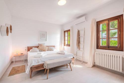 a white bedroom with a large bed and a window at Casa del Puerto in Port de Soller
