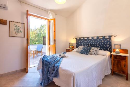a bedroom with a bed and a sliding glass door at Casa con terrazza nella Pineta in Codaruina