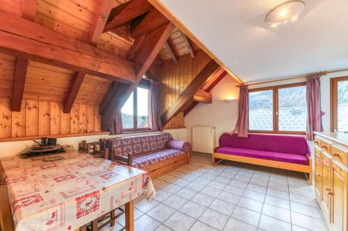 a living room with purple furniture and wooden ceilings at Chalet de l'Ardoisière in Saint-Colomban-des-Villards