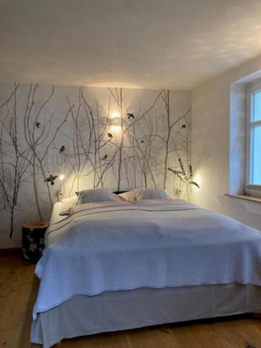 a bedroom with a bed with branches on the wall at Ferienhaus bei Juste in Schotten