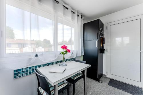 a white table with a vase with a rose on it at Studio chez Brigitte à Audenge in Audenge