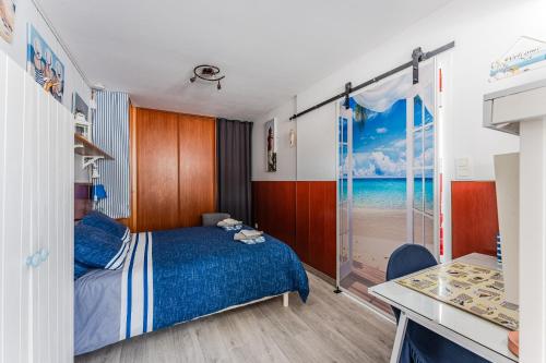 a bedroom with a bed and a desk and a window at Studio chez Brigitte à Audenge in Audenge