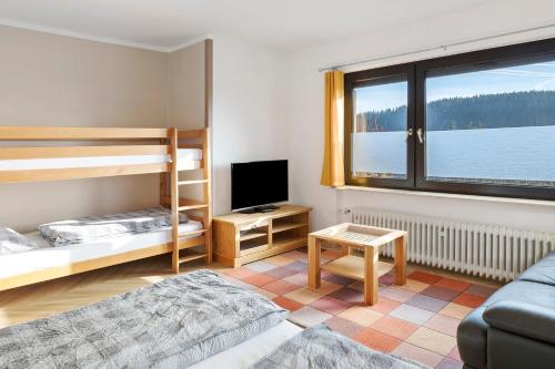 a room with two bunk beds and a television at Haus Wintersonne in Feldberg