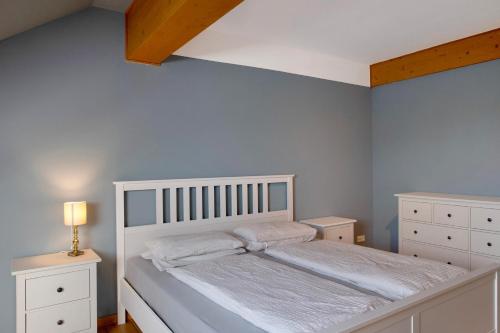 a bedroom with a white bed and two night stands at Gutshaus am Teich in Neukloster