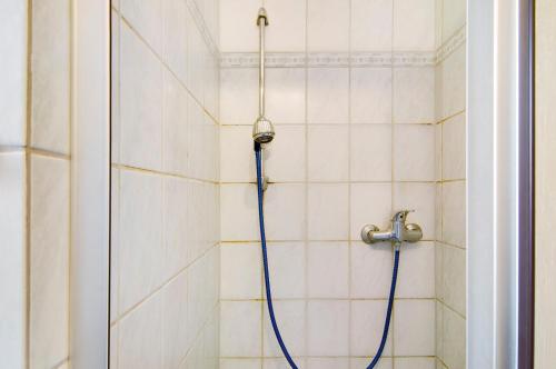 a shower with a blue hose in a bathroom at Ferienwohnungen Schmitz in Wangerland