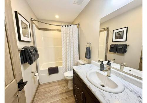 a white bathroom with a sink and a toilet at Sunny Peaks in Valemount