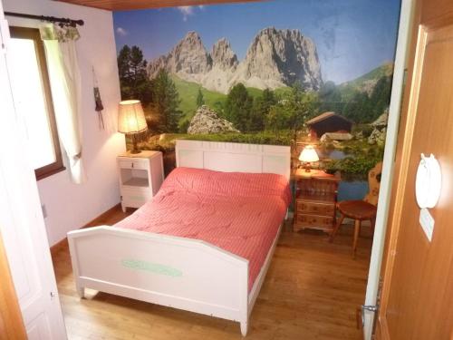 a bedroom with a bed with a mountain mural on the wall at Chalet St Victoire - Les Orres in Les Orres