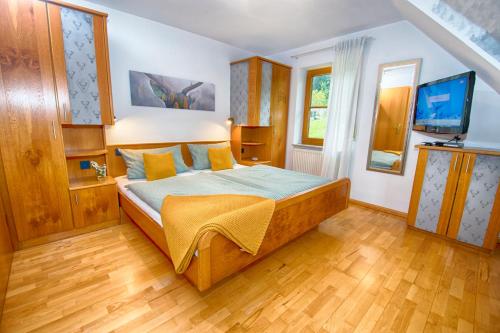 a bedroom with a bed and a television in it at Trenklehof in Simonswald