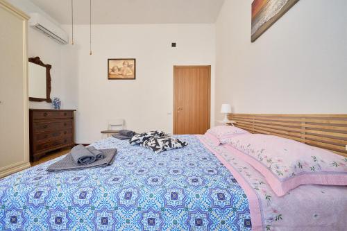a bedroom with a bed with a blanket and a dresser at Casabaffo in Piombino