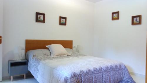 a bedroom with a bed and pictures on the wall at Apartament Can Pujadas in Regencós