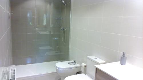 a bathroom with a toilet and a glass shower at Apartament Can Pujadas in Regencós
