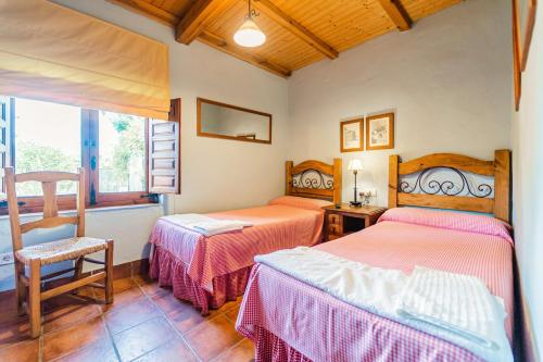 a bedroom with two beds and a window at El Colono El uncar in Castrejón de la Peña