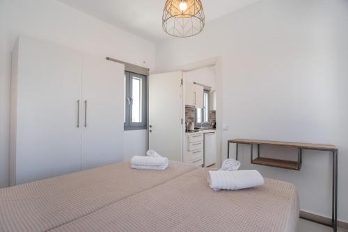 a white bedroom with a bed with towels on it at Villa Anastasio in Kampos Paros