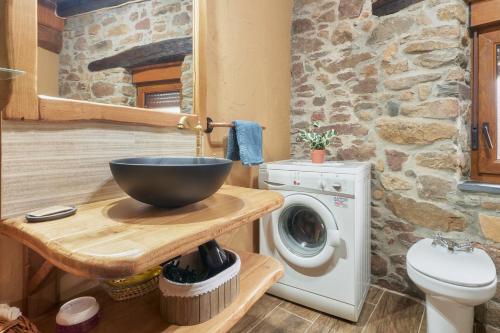 a bathroom with a bowl sink and a washing machine at Casa Rural Abuelo Jose in Robledo de las Traviesas