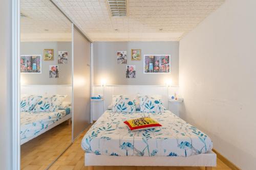 a bedroom with two beds and a mirror at Les Cerisiers in Apt