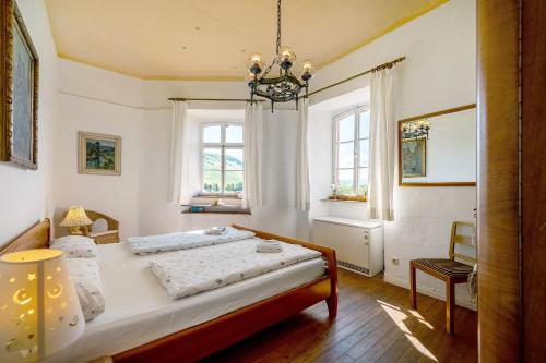 a bedroom with a bed and two windows at Ferienwohnung Abtei Klosterhof in Maring-Noviand