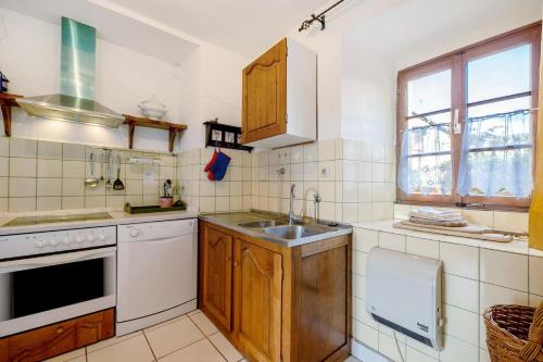 a kitchen with wooden cabinets and a sink at Ferienwohnung Abtei Klosterhof in Maring-Noviand