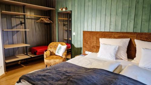 a bedroom with a bed and a chair at Franz Josefs Wald-Chalets in Untergriesbach