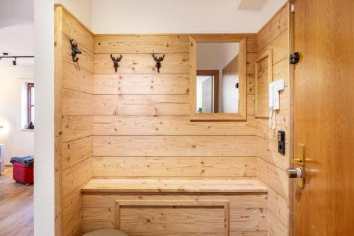 a bathroom with a wooden wall at Ammerstube Oberammergau in Oberammergau