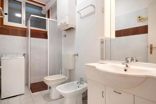 a white bathroom with a sink and a toilet at Terrazza Sivori in Bonassola