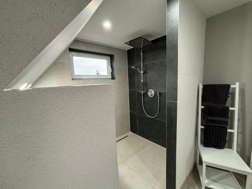 a bathroom with a walk in shower and a window at Schorsch's Ferienhaus in Winzeln