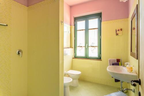 a bathroom with a sink toilet and a window at Alba al Rifugio Arcobaleno in Popiglio