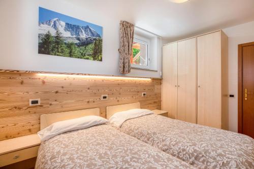 a bedroom with two beds and a mountain at Casa Penasa App 3 in Commezzadura