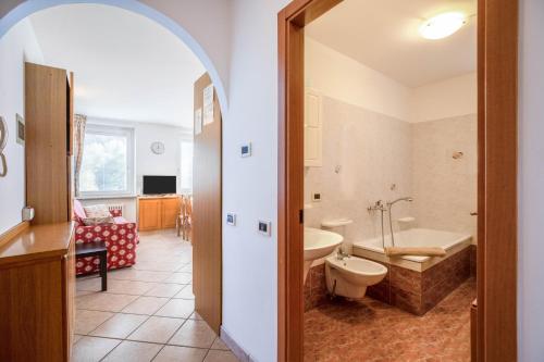 a bathroom with a tub and a sink and a toilet at Casa Penasa App 3 in Commezzadura