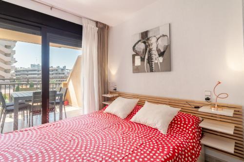 a bedroom with a red and white bed and a balcony at Luxury flat beach ressort sea view in Arenales del Sol