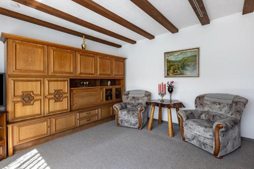 a living room with two chairs and a television at Ferienwohnung Regina in Furtwangen