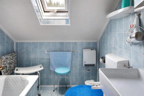 a bathroom with a blue tiled floor and a blue stool at Apartmenthaus Fister in Schluchsee